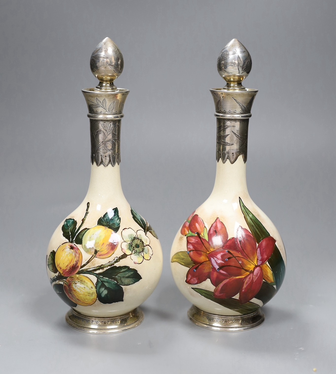 A pair of Victorian silver mounted Art pottery scent bottles, 21.5cms high including stopper